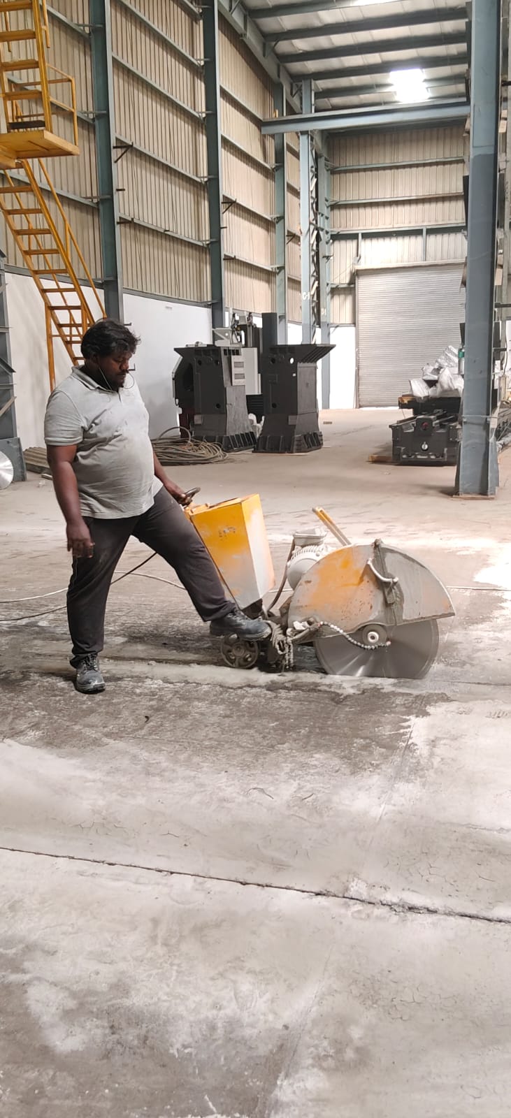 Operator using a floor saw in an industrial facility