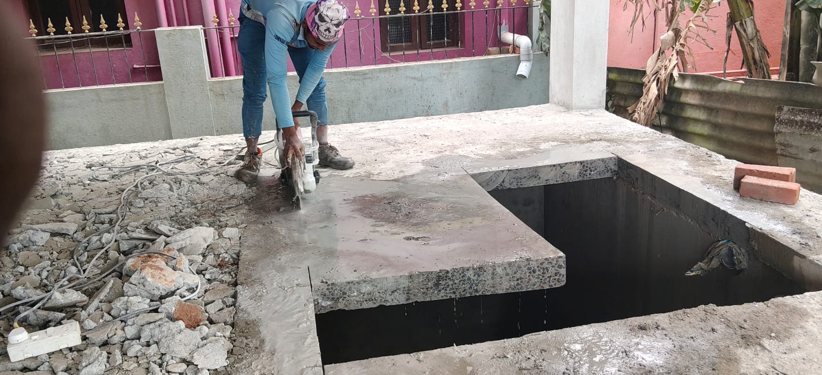 Worker cutting a concrete slab section on site